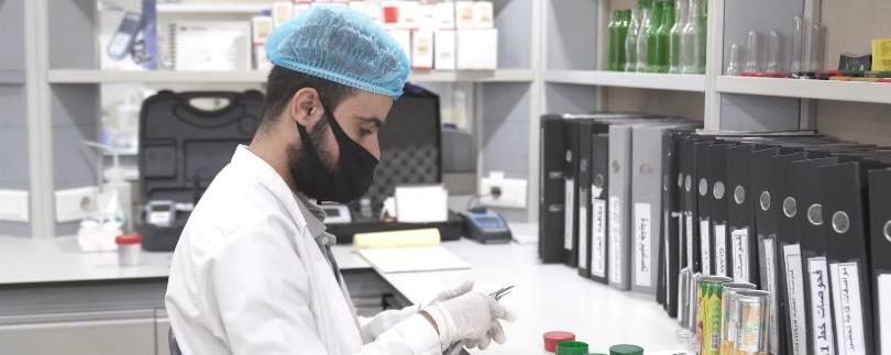 Lab technician in a hairnet testing samples