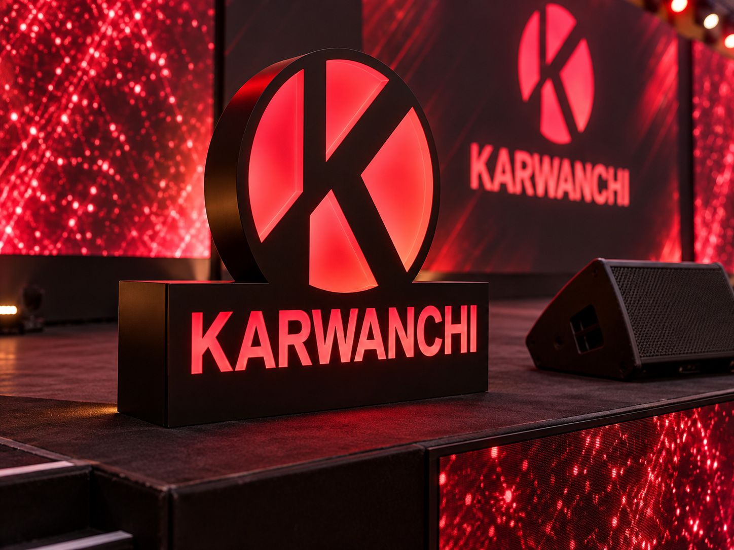 Illuminated Karwanchi logo sculpture at the stage end