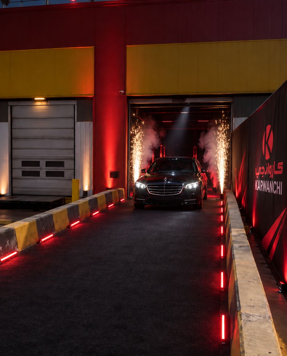 Prize car rolling out of the warehouse between spark fountains and smoke